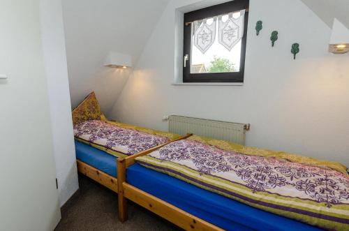 a small bed in a room with a window at 3-R-Ferienwohnung-fuer-3-Personen-in-Schaprode-auf-Ruegen-Zi4 in Schaprode