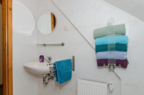 a white bathroom with a sink and towels at 3-R-Ferienwohnung-fuer-3-Personen-in-Schaprode-auf-Ruegen-Zi4 in Schaprode