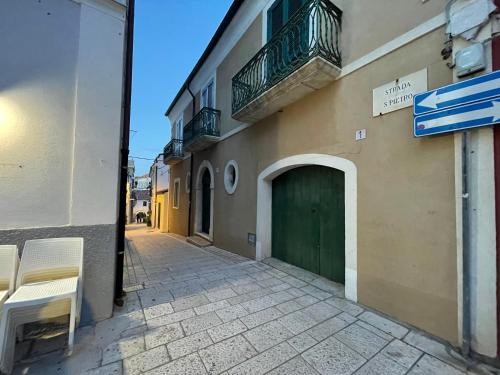 un edificio con una puerta verde y una calle en La Finestra Sul Porto en Termoli