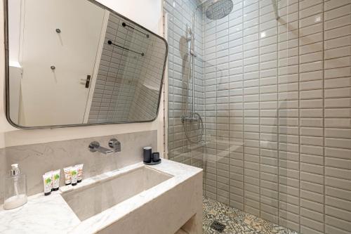 une salle de bain avec un lavabo et une douche avec un miroir dans l'établissement Luxurious flat in the heart of Cannes, à Cannes