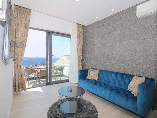 Sala de estar con sofá azul y vistas al océano en Luxury Amarin Apartment en Dubrovnik