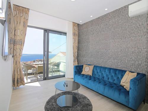 a living room with a blue couch and a view of the ocean at Luxury Amarin Apartment in Dubrovnik
