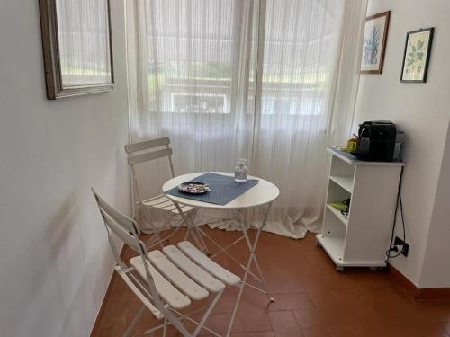 een kleine tafel en stoelen in een kamer met een raam bij La Casa del Sole in Fresonara