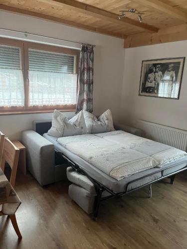 a bed sitting in a room with a window at App. Daverda Walter Strada al Plan Dessora 26 in San Vigilio Di Marebbe