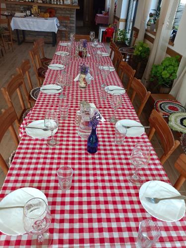 a long table with a red and white checkered table cloth at Fruškogorski Đeram in Grgeteg