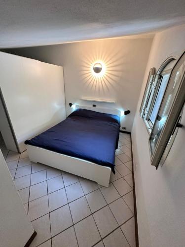 a bedroom with a bed with a light on the ceiling at Le vasche - by the sea - nice apartment in Cavo
