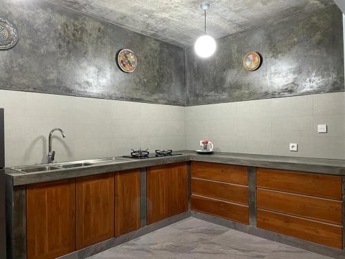 a kitchen with wooden cabinets and a sink at Mojito Beach Villas in Kubutambahan