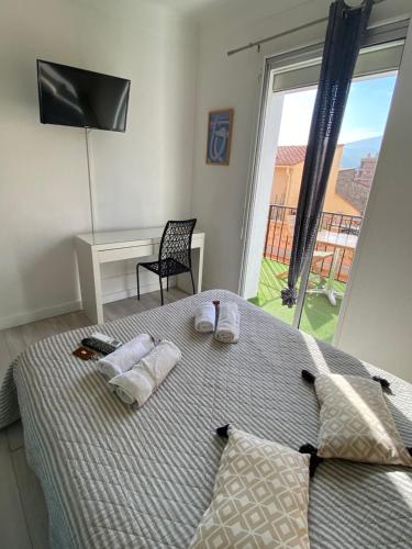a bedroom with a bed with two towels and a window at Hotel Les Pecheurs in Banyuls-sur-Mer