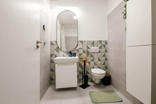 uma casa de banho com um lavatório, um espelho e um WC. em Luxury Apt. Near River & Parking em Timisoara