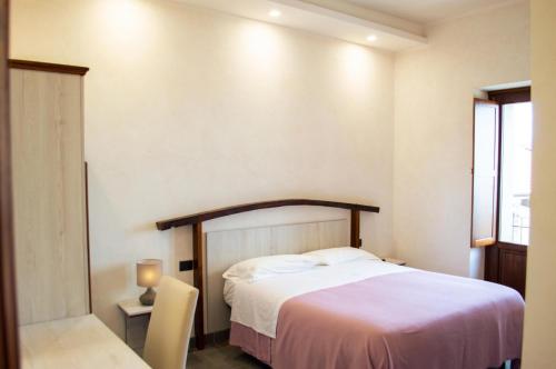 a bedroom with a white bed and a window at Palazzo Iaquinta - Rooms, Restaurant & Wellness in Cicerale