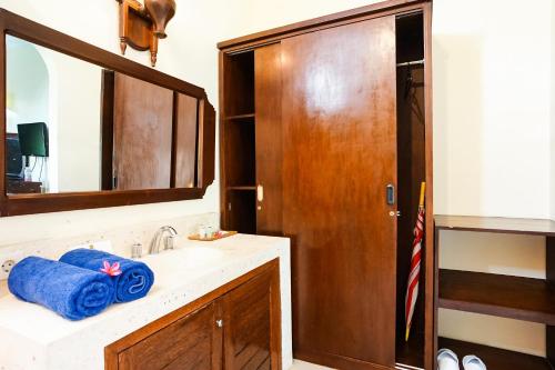 a bathroom with a sink and a mirror at Taman Ayu Legian Hotel in Legian