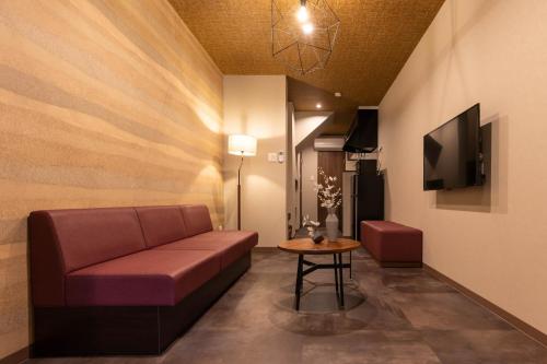 a living room with a couch and a table at Bijou Suites Classic in Osaka