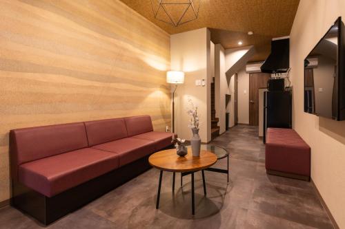 a living room with a couch and a table at Bijou Suites Classic in Osaka