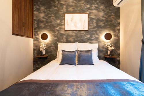 a bedroom with a bed with two blue pillows at Bijou Suites Classic in Osaka