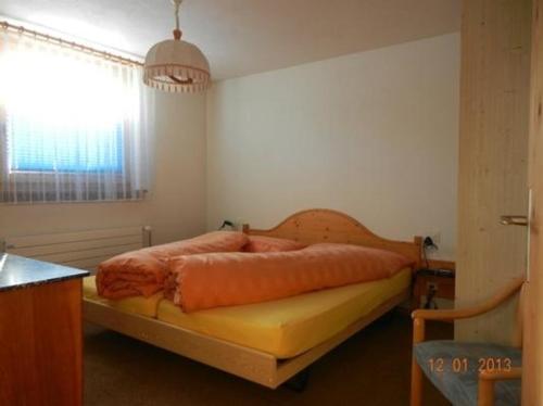 een slaapkamer met een bed in een kamer met een raam bij Alvetern Tschuetta in Scuol