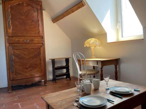 - une table à manger avec des assiettes et des verres dans l'établissement Loft Marguerite de Bourgogne, à Tonnerre