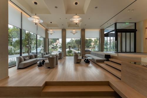 a lobby with couches and tables and windows at Emmantina Hotel in Athens