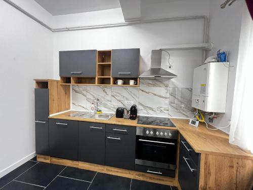 a kitchen with black and white appliances and a counter at Cozy Aparthotel - Central City Suceava in Suceava