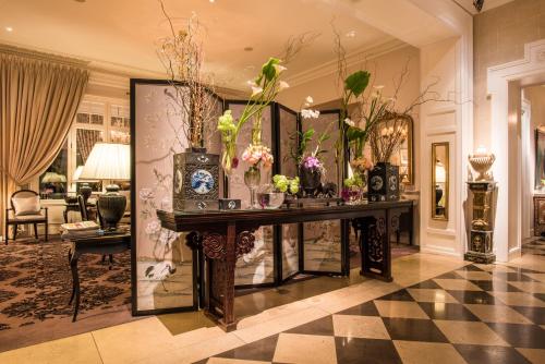 a living room with a table with vases of flowers at Grand Hotel du Lac - Relais & Châteaux in Vevey