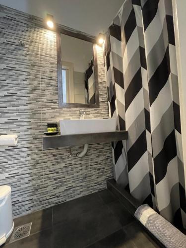 a bathroom with a sink and a mirror at Manto Apartments in Tinos