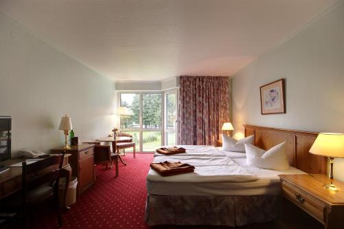 a hotel room with a bed and a window at Hotel Fährkrug in Templin