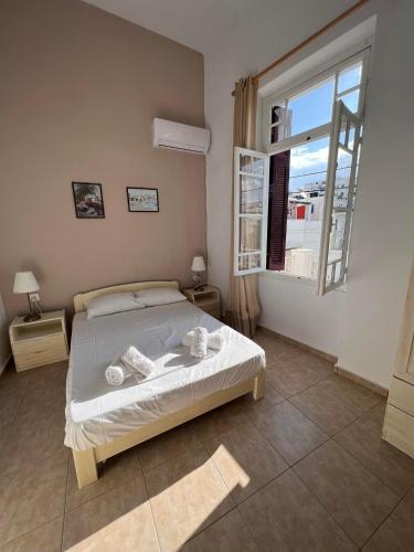 a bedroom with a bed and a large window at Tinos Central Perfection in Tinos