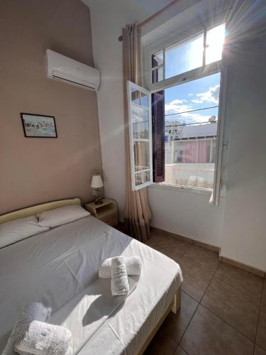 a bedroom with a white bed and a window at Tinos Central Perfection in Tinos