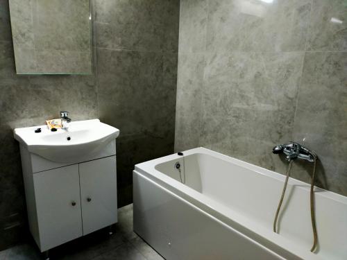 La salle de bains est pourvue d'un lavabo, d'une baignoire et d'une baignoire blanche. dans l'établissement Casa Olanescu Vâlcea, à Râmnicu Vâlcea