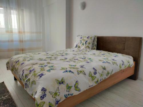 - une chambre avec un lit doté d'un couvre-lit avec des papillons dans l'établissement Casa Olanescu Vâlcea, à Râmnicu Vâlcea