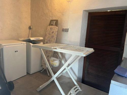 einen weißen Tisch in einem Zimmer mit Tür in der Unterkunft Spacieux studio vue panoramique in Propriano