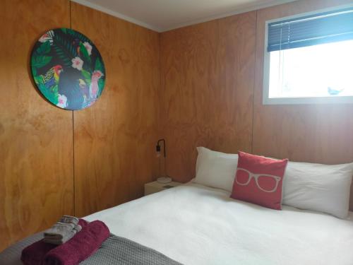 1 dormitorio con cama, ventana y espejo en The Old Sunday School en Dunedin