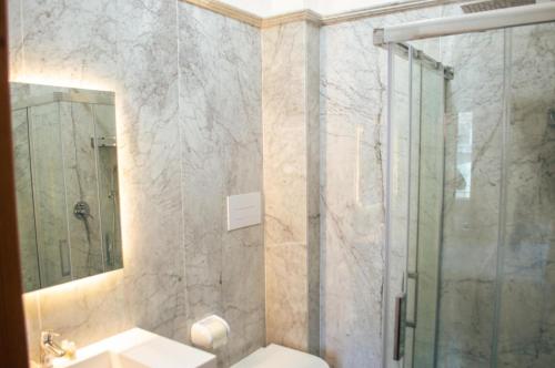 a bathroom with a shower and a toilet and a sink at Palazzo Iaquinta - Rooms, Restaurant & Wellness in Cicerale