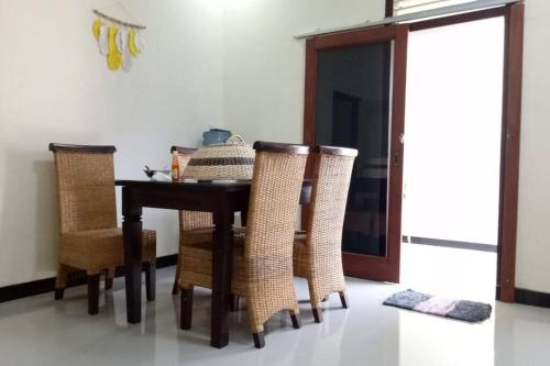 uma sala de jantar com uma mesa e algumas cadeiras em Aprilia Homestay Magelang em Magelang