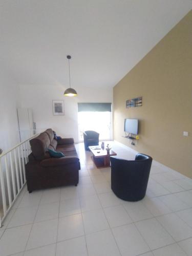 a living room with two couches and a table at Pérola de Sandy in Paderne