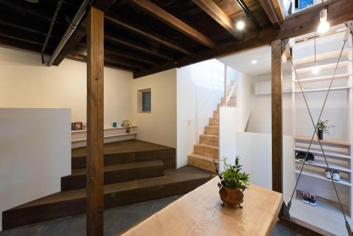 una habitación con escaleras y una mesa con una maceta en Bokuyado Nishijin, en Kioto