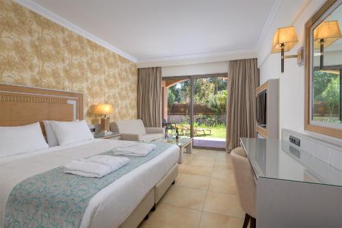 a hotel room with a bed and a television at La Marquise Luxury Resort Complex in Faliraki