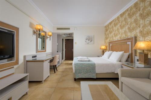 ファリラキにあるラ マルキーズ ラグジュアリー リゾート コンプレックスのベッドとテレビ付きのホテルルーム