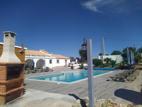 a swimming pool in front of a house at Pérola de Sandy in Paderne