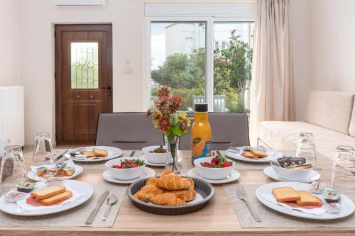 une table avec des assiettes de nourriture au-dessus dans l'établissement Barbaras Apartments, à Kato Daratso