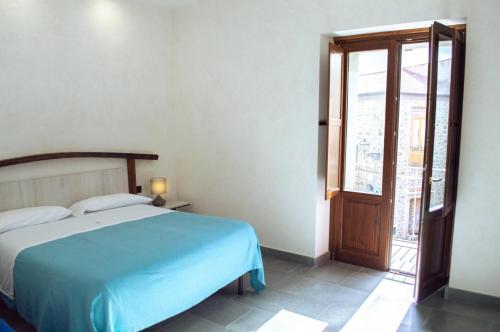Un dormitorio con una cama azul y una ventana en Palazzo Iaquinta - Luxury Rooms & Wellness en Cicerale
