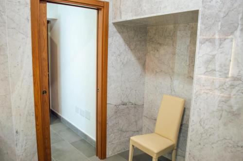 a white chair and a mirror in a room at Palazzo Iaquinta - Rooms, Restaurant & Wellness in Cicerale