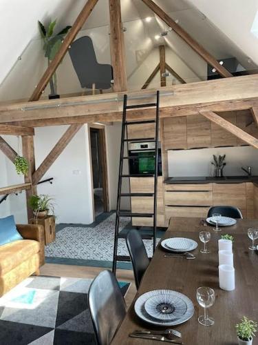une chambre avec une table, des chaises et une mezzanine dans l'établissement Gîte à 10 min d'Europa-park, à Rhinau