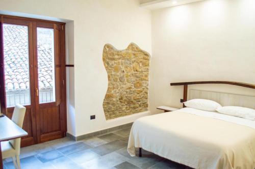 um quarto com uma cama e uma grande janela em Palazzo Iaquinta - Luxury Rooms & Wellness em Cicerale