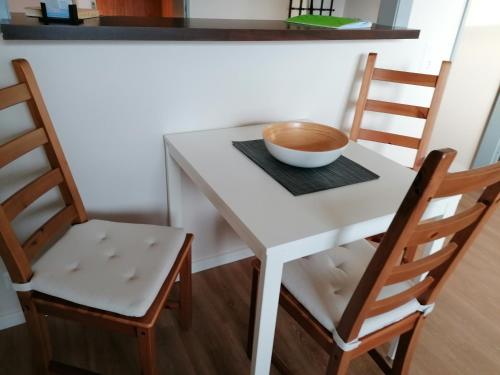 a small white table with two chairs and a bowl on it at Jana's Fewo in Lübeck
