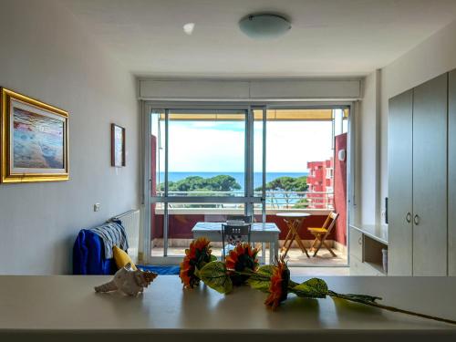 una cucina con tavolo e fiori di Casa Pinolo Monolocale Vista Mare a Follonica