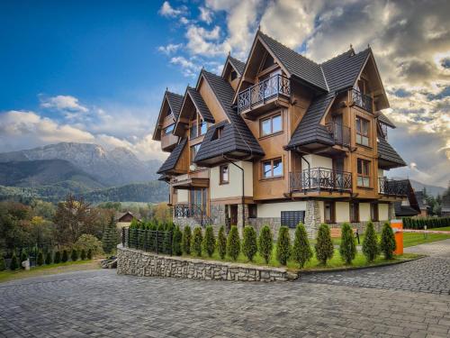 een groot houten huis met een dak bij VisitZakopane - Chalet Ski Apartment in Zakopane