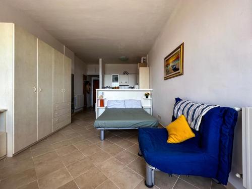 - un salon avec un canapé bleu et un lit dans l'établissement Casa Pinolo Monolocale Vista Mare, à Follonica