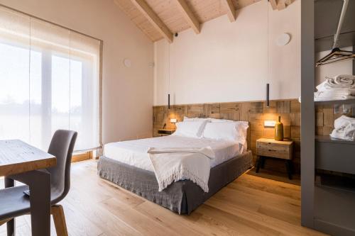 a bedroom with a bed and a desk and a window at Agri-relais Ventisettegradi in Montemarciano