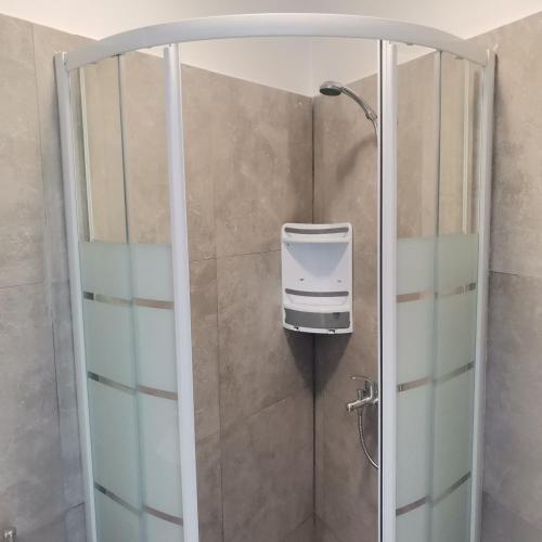 a shower stall with a soap dispenser on the wall at Seafront Aegean Νest in Karpathos
