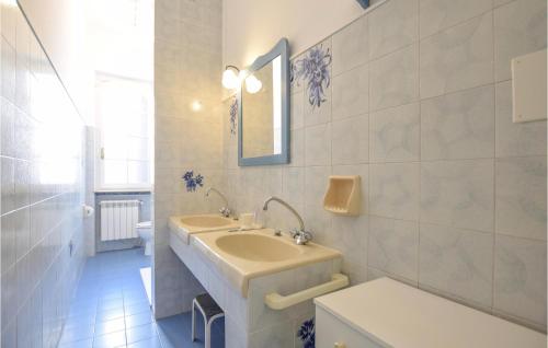 ein Badezimmer mit einem Waschbecken, einem Spiegel und einem WC in der Unterkunft Gorgeous Home In Viareggio With Kitchen in Viareggio